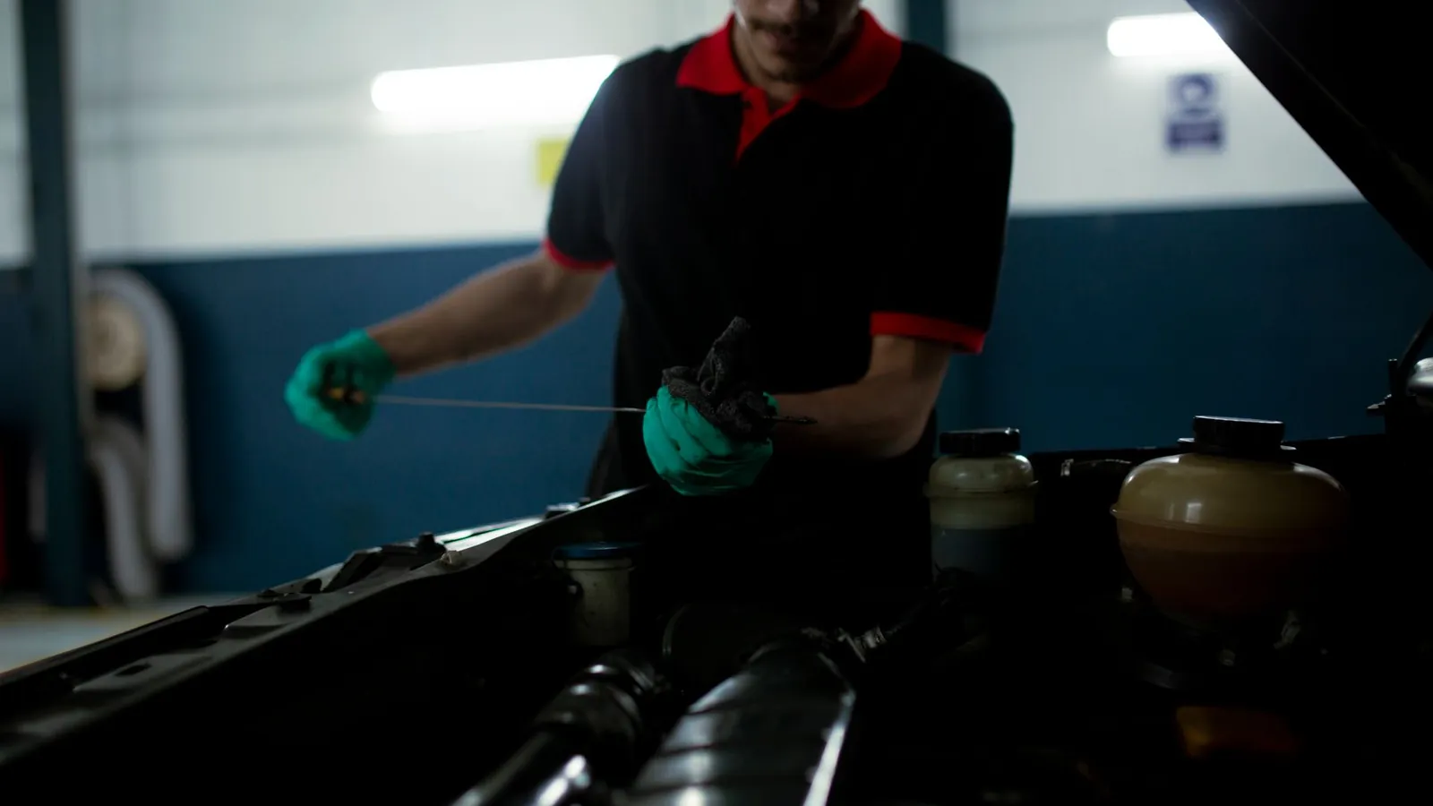 Mechanic checking engine oil with a dipstick