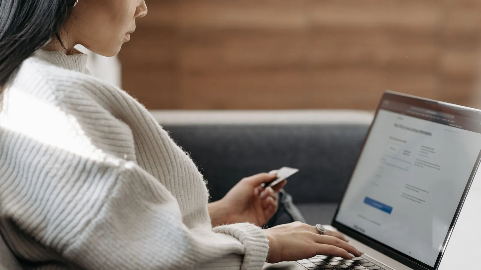 Person entering card details on a laptop