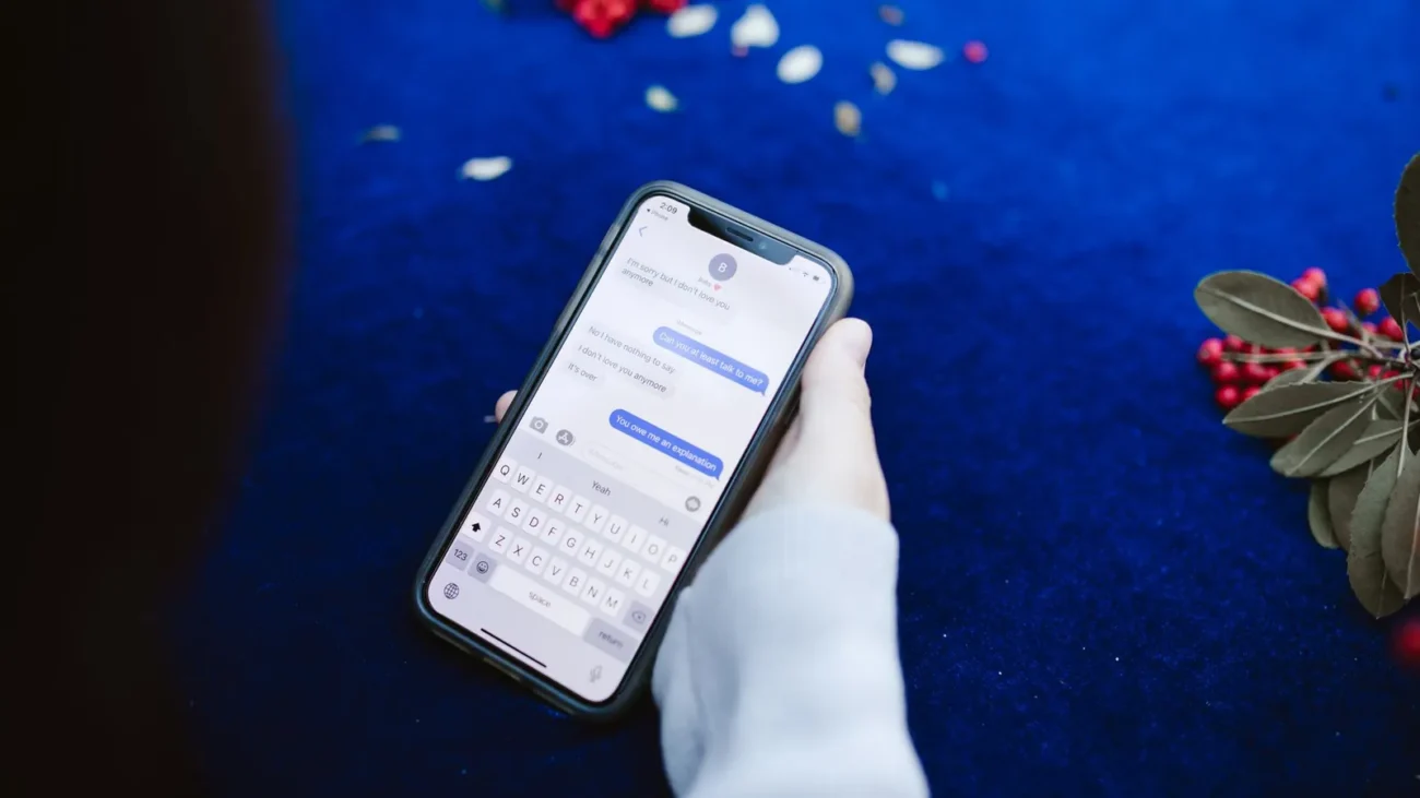Hand holding a smartphone showing text messages
